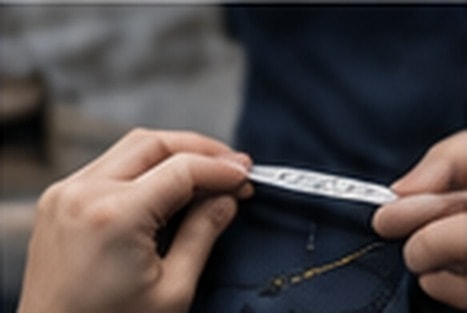 Close-up of hands checking garment stitching and finish